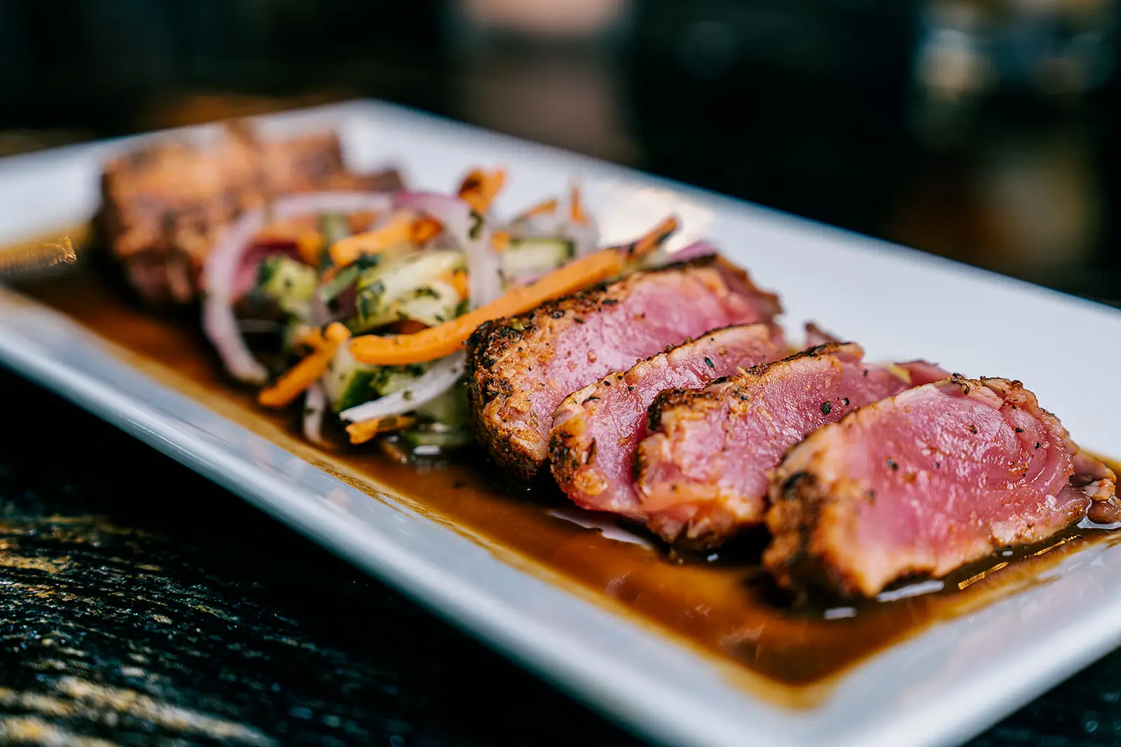 Seared Ahi Tuna steak slices with house specialty sauce by the 8th Street at the Ivy