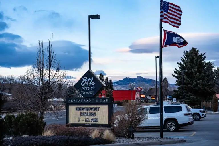 Street signage of the 8th Street at the Ivy flanked by the US flag and the flag of Wyoming