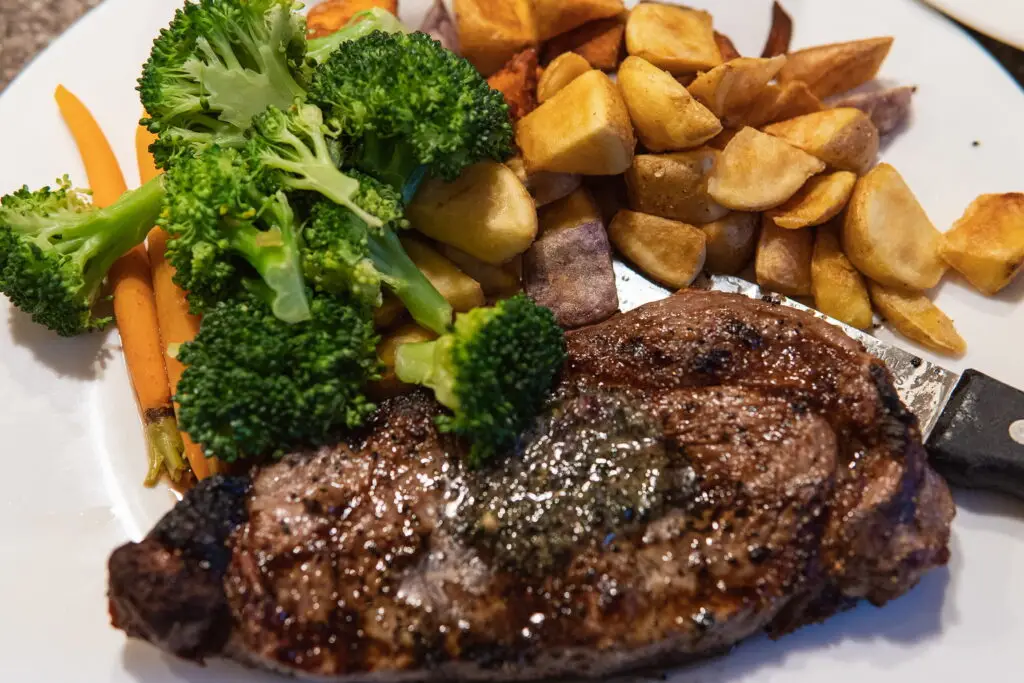 Steak served with a side of potatoes, broccoli and carrot by the 8th Street at the Ivy