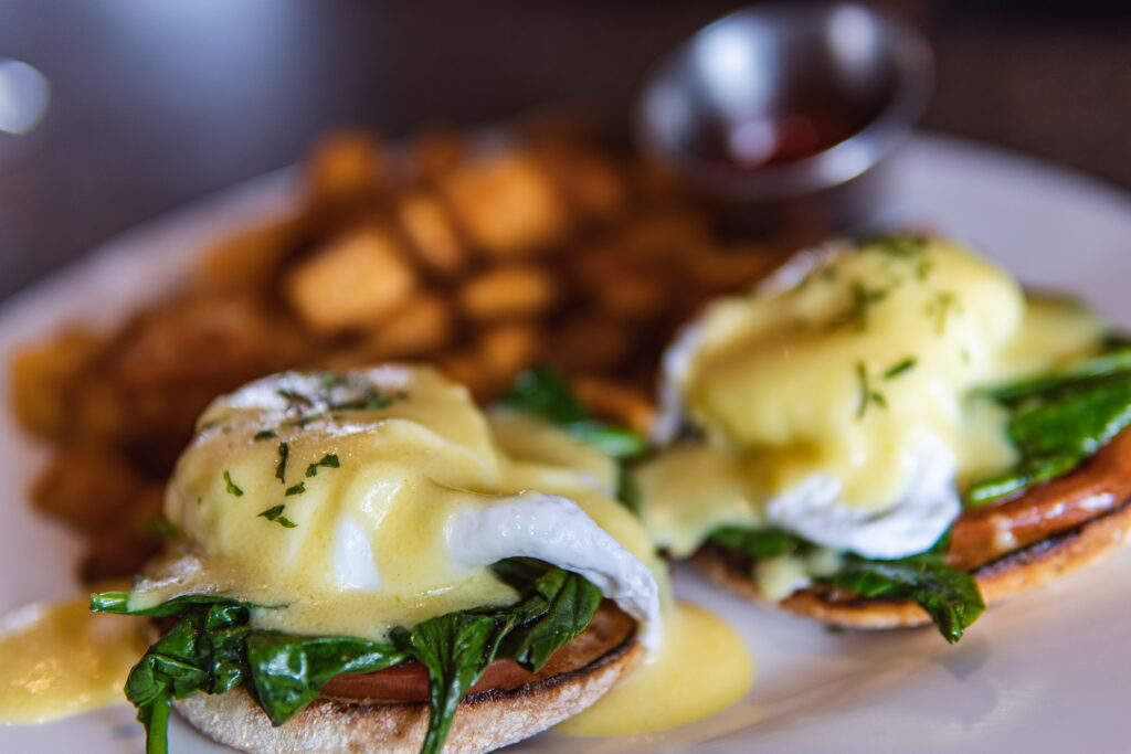 2 Poached eggs, sautéed spinach & tomato on a crisp English muffin topped with Hollandaise and potatoes.